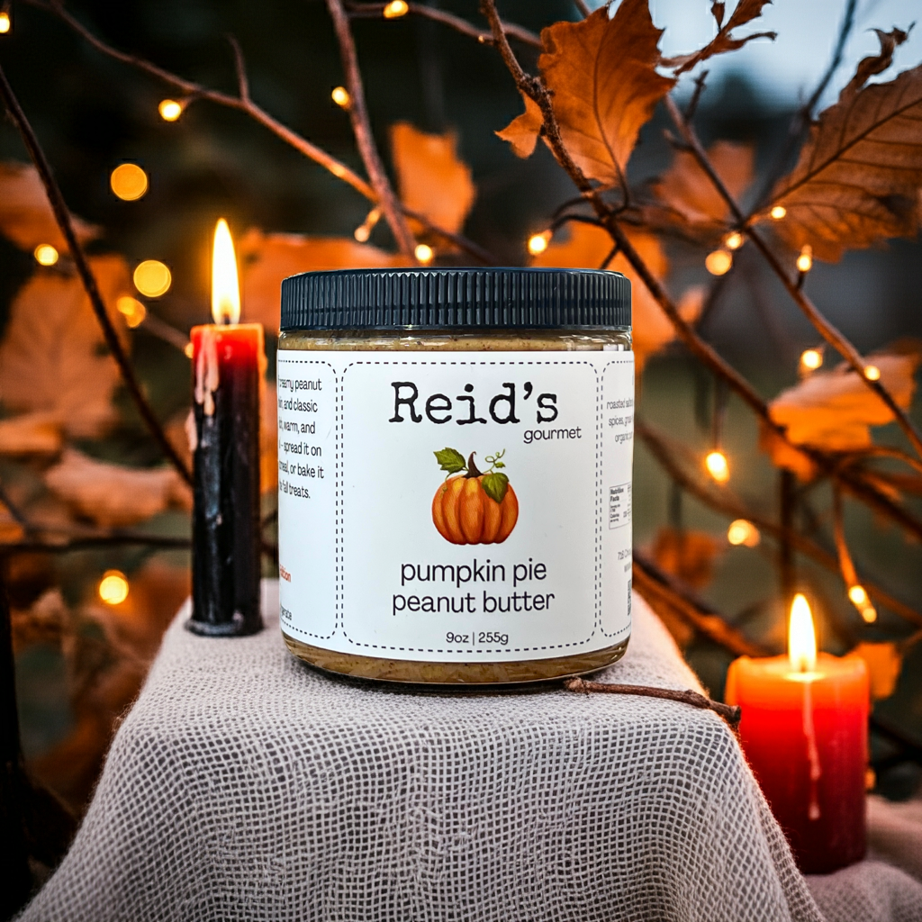 Jar of Reid's Gourmet pumpkin pie peanut butter with autumn decorations and candles in the background