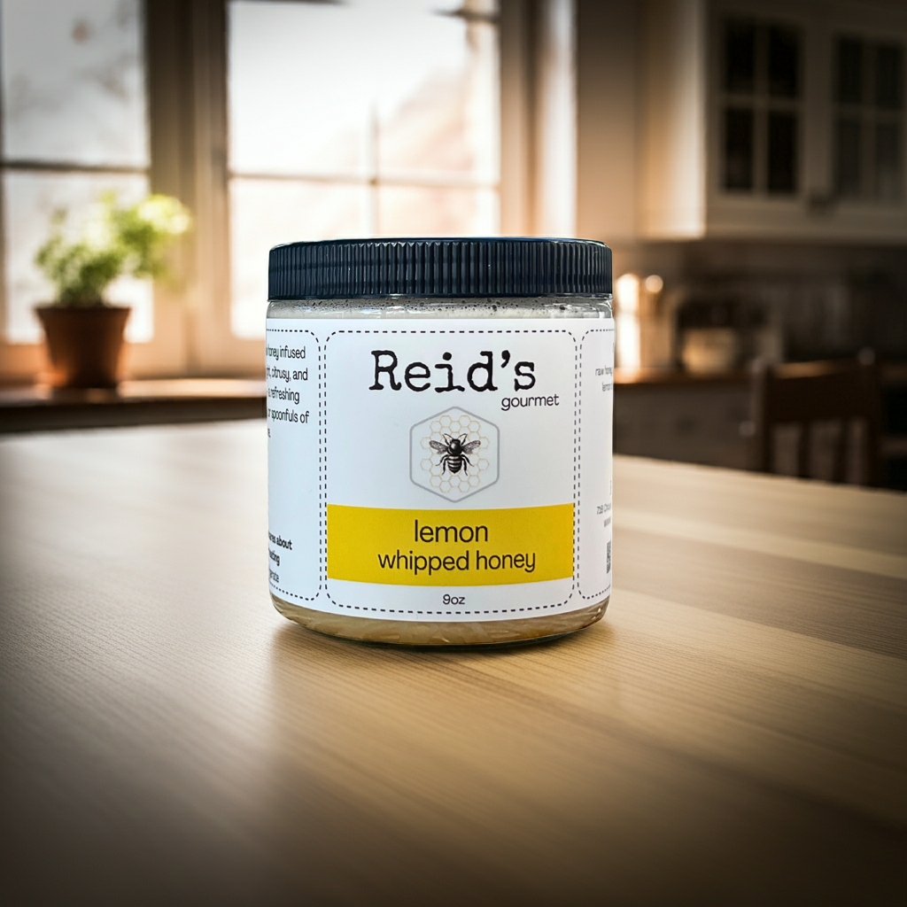 Jar of Reid's Gourmet lemon whipped honey on a wooden table with a kitchen background